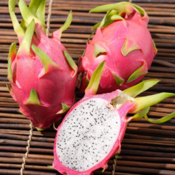 Freshly sliced dragon fruit showing bright pink skin and white flesh speckled with black seeds.